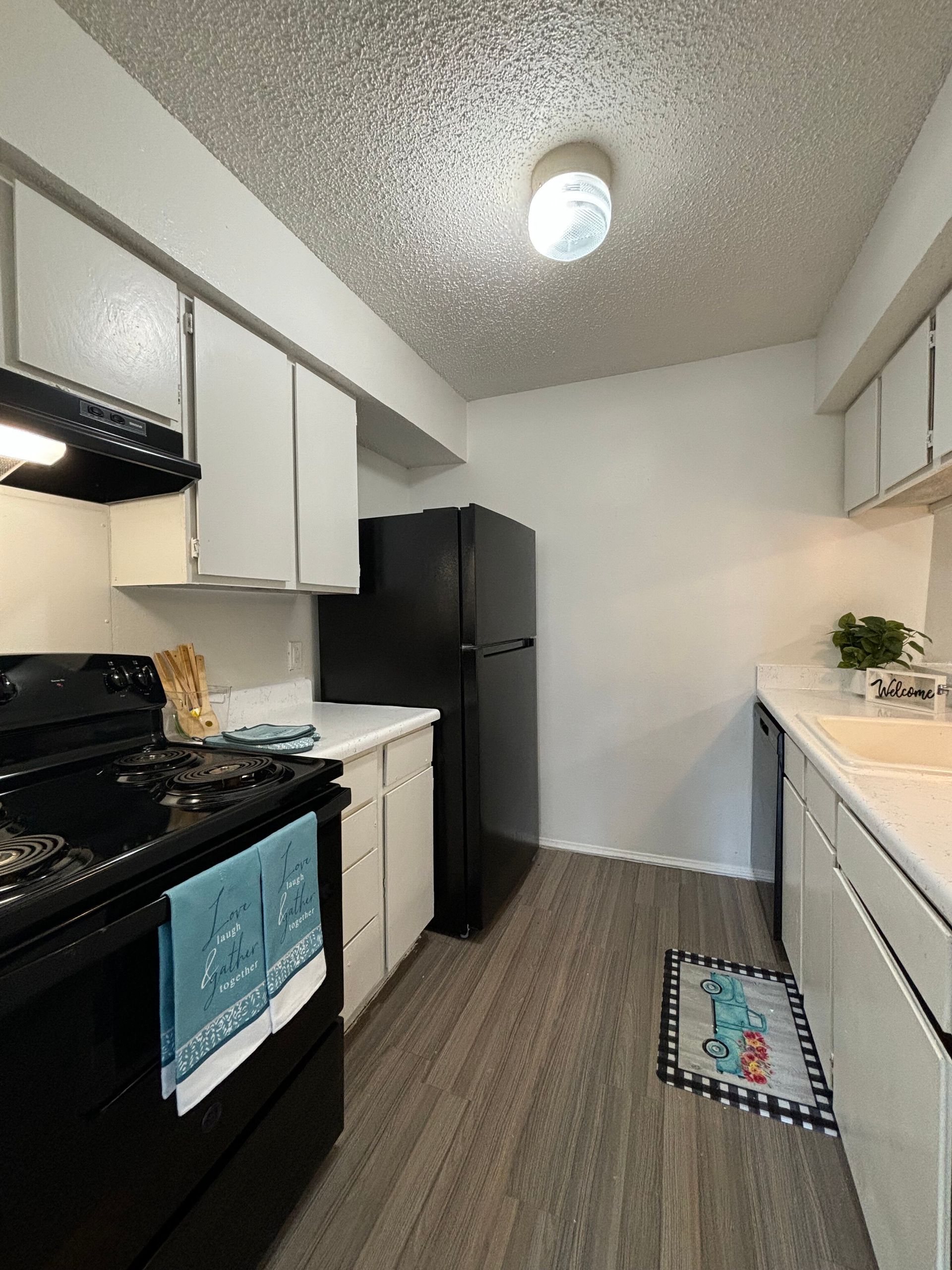 A kitchen with a black refrigerator and white cabinets