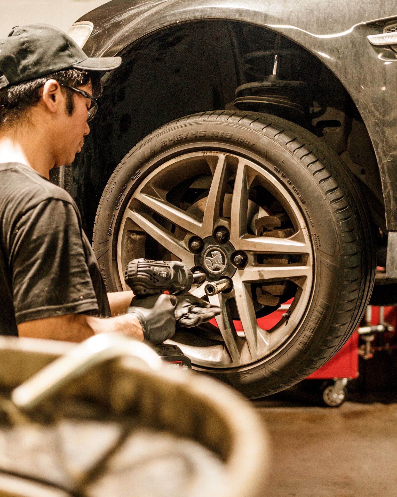 a man is changing a tire on a car in a garage .
