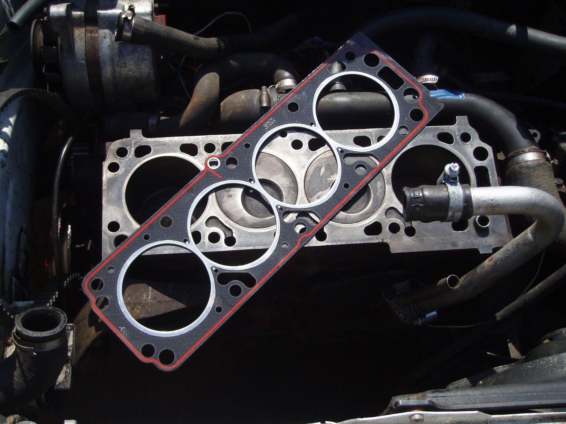 a cylinder head gasket is sitting on top of a car engine