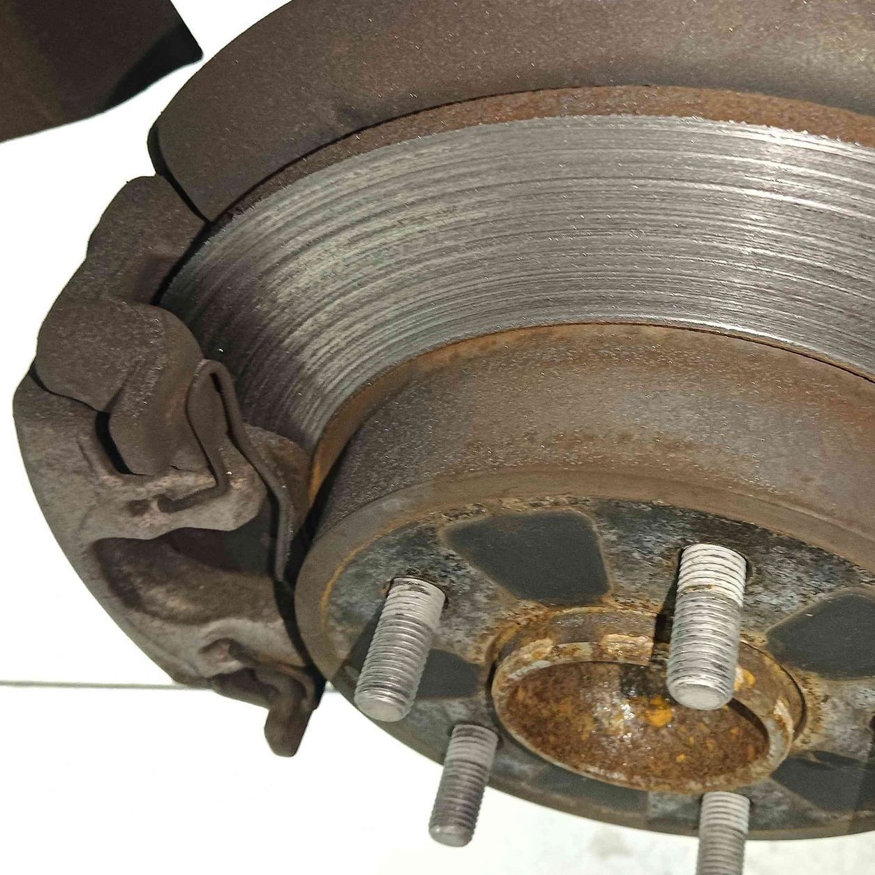 a close up of a rusty brake disc on a white background