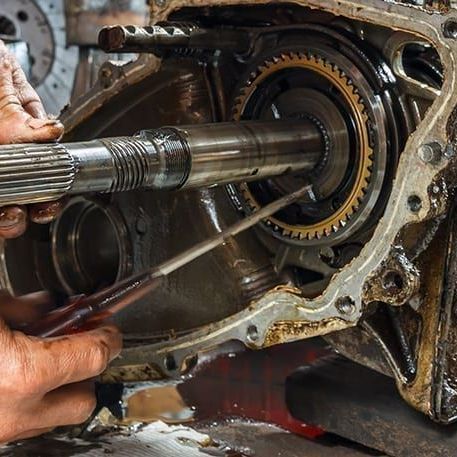 a person is working on a car engine with a screwdriver .