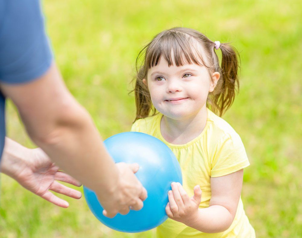 Little Girl Playing With A Ball — Better Access Support Services In Gatton, QLD
