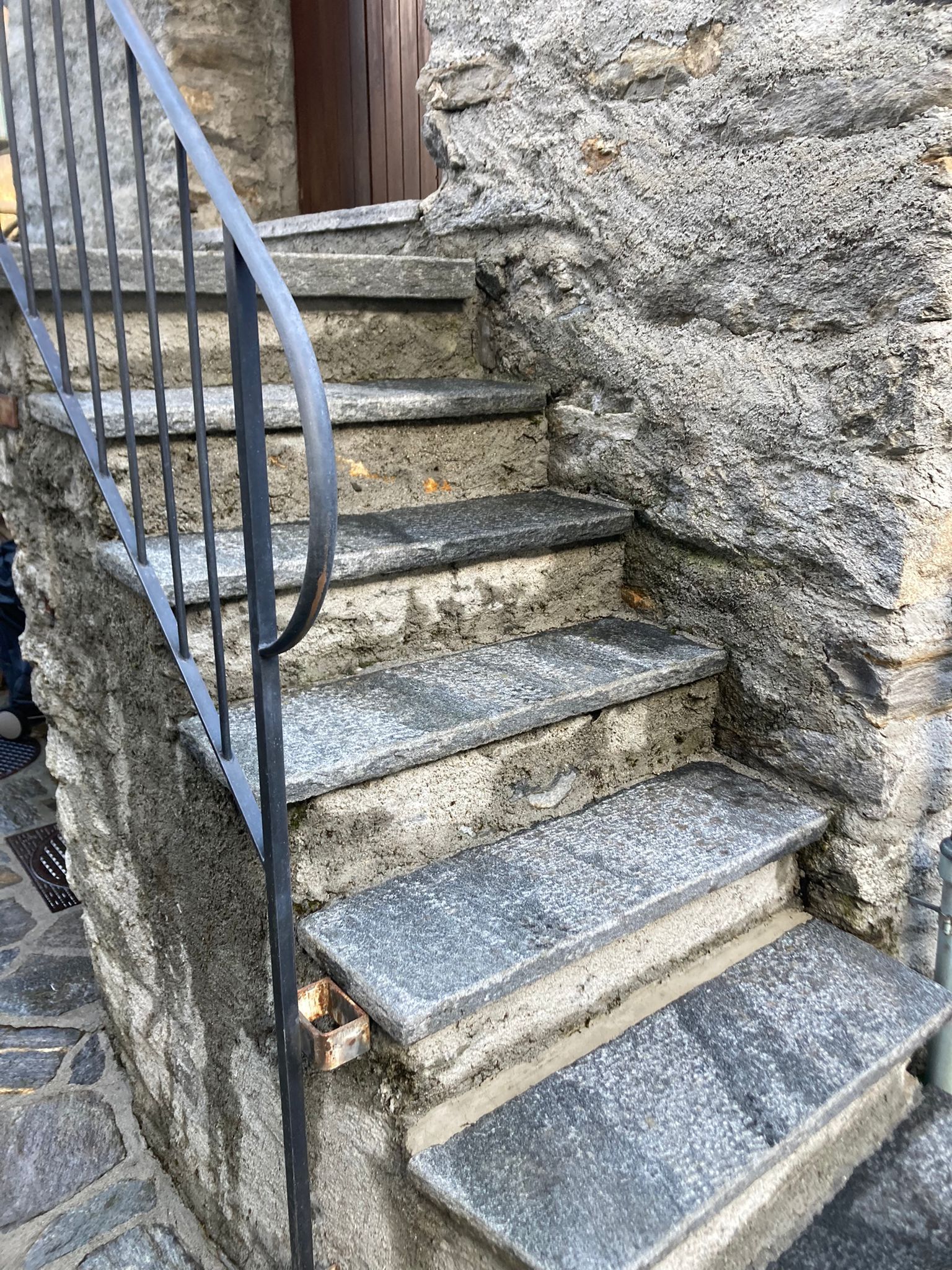 Una rampa di scale in pietra con ringhiera in metallo.