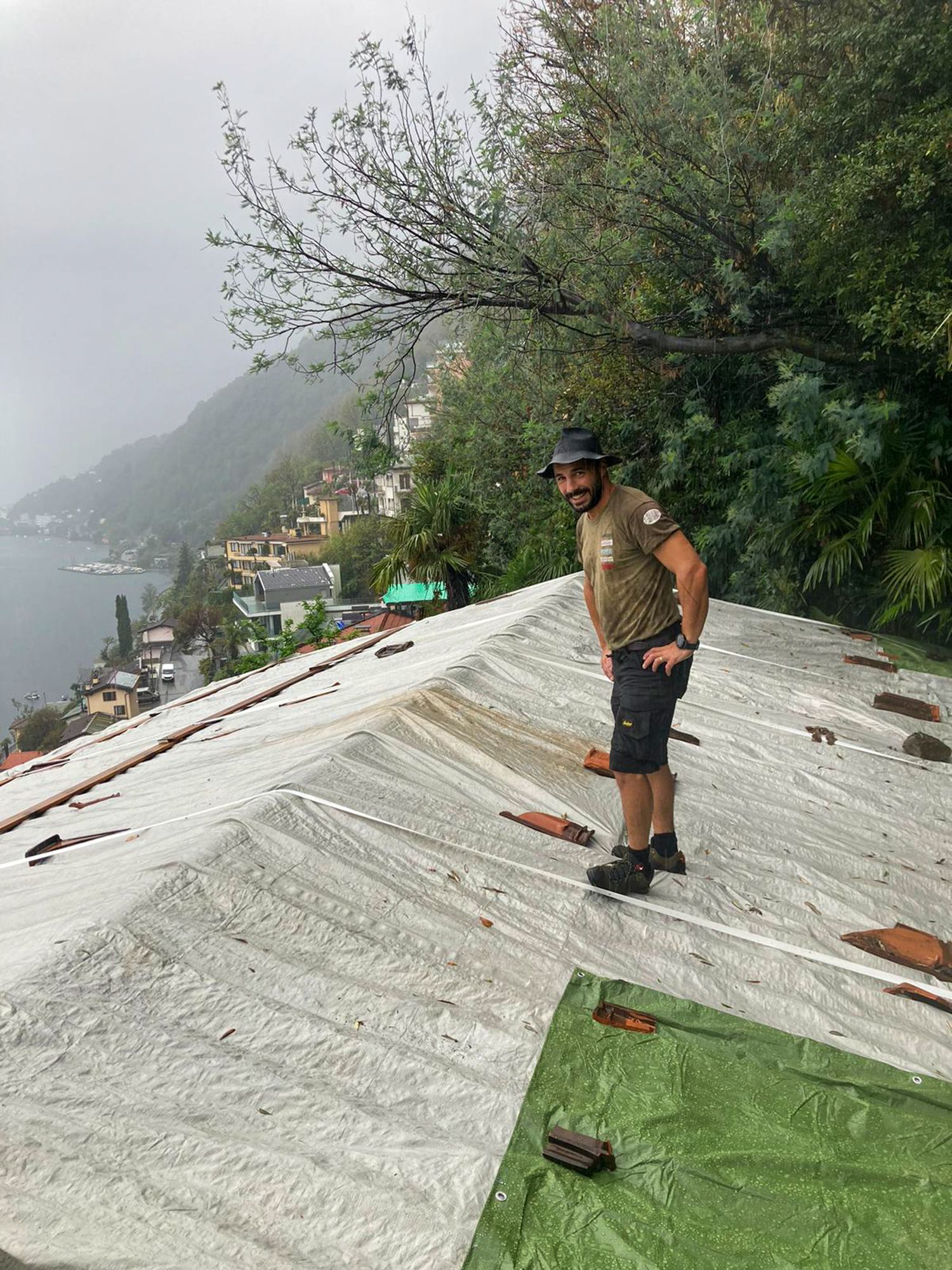 Un uomo è in piedi sopra un tetto ricoperto di plastica.