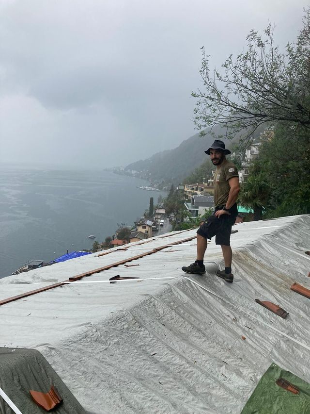 Un uomo è in piedi in cima a un tetto che si affaccia sull'oceano.