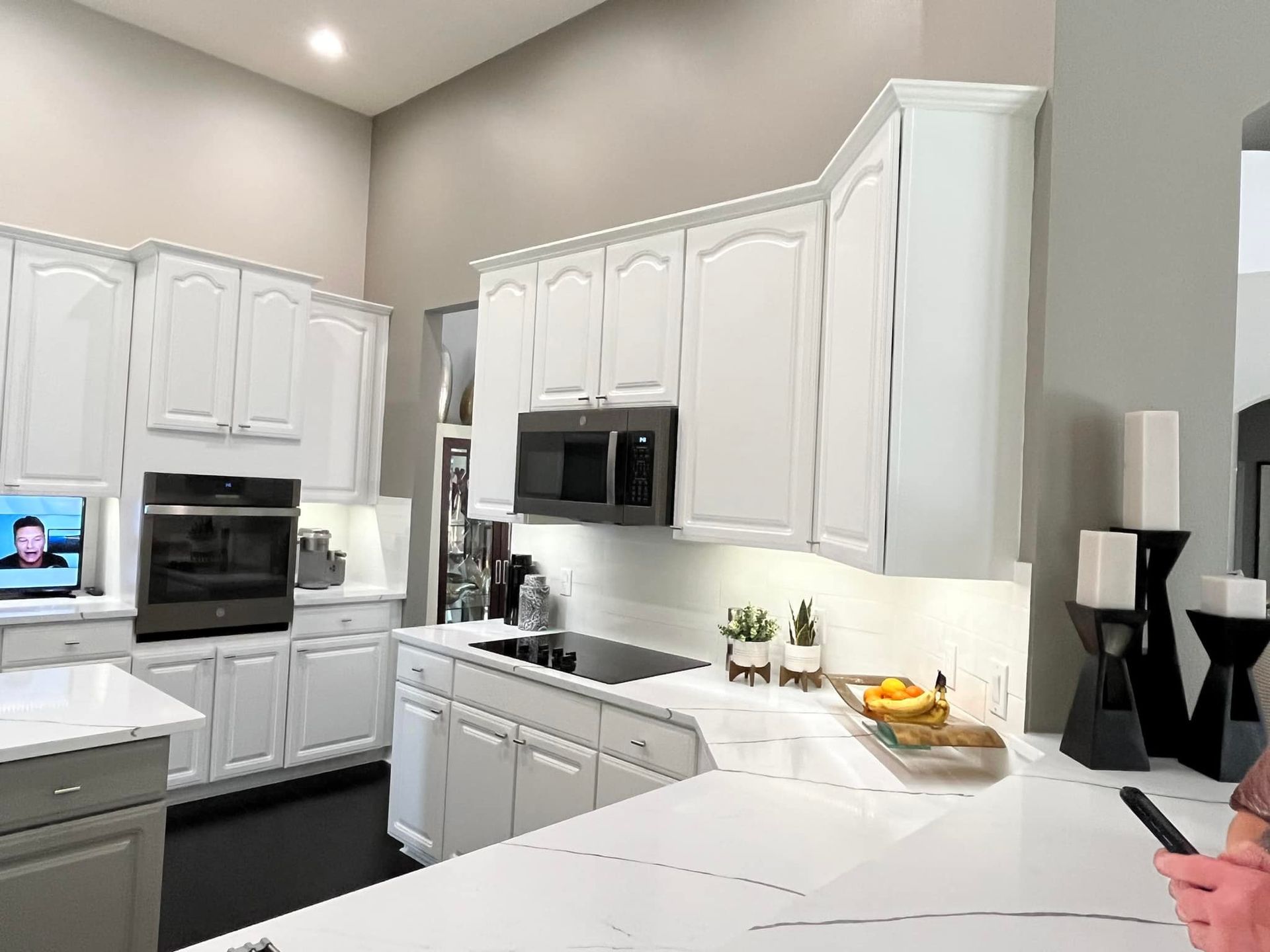 White kitchen with cabinets, oven, microwave, and countertop.