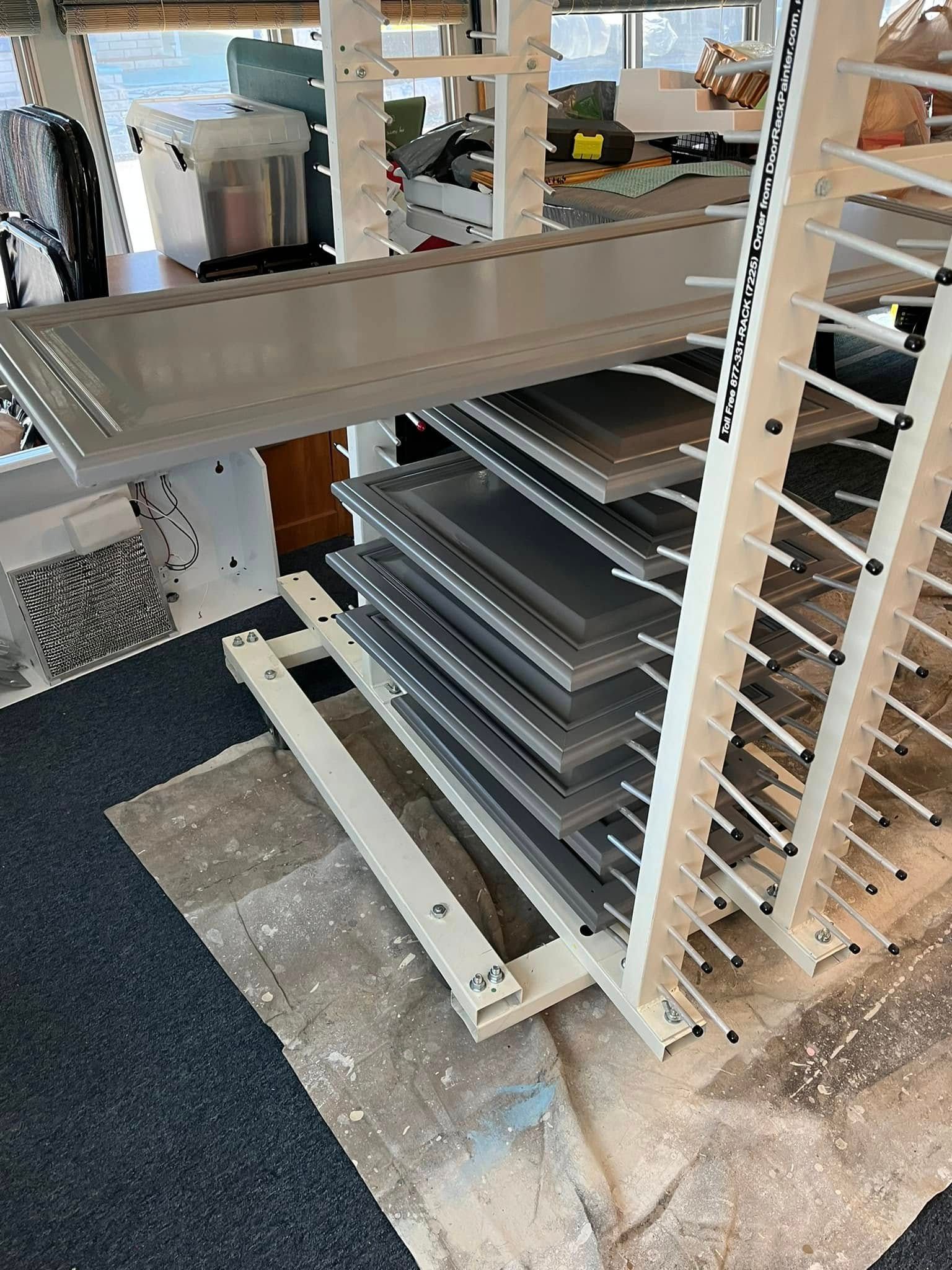 Metal sheets stacked on a vertical storage rack in a room.