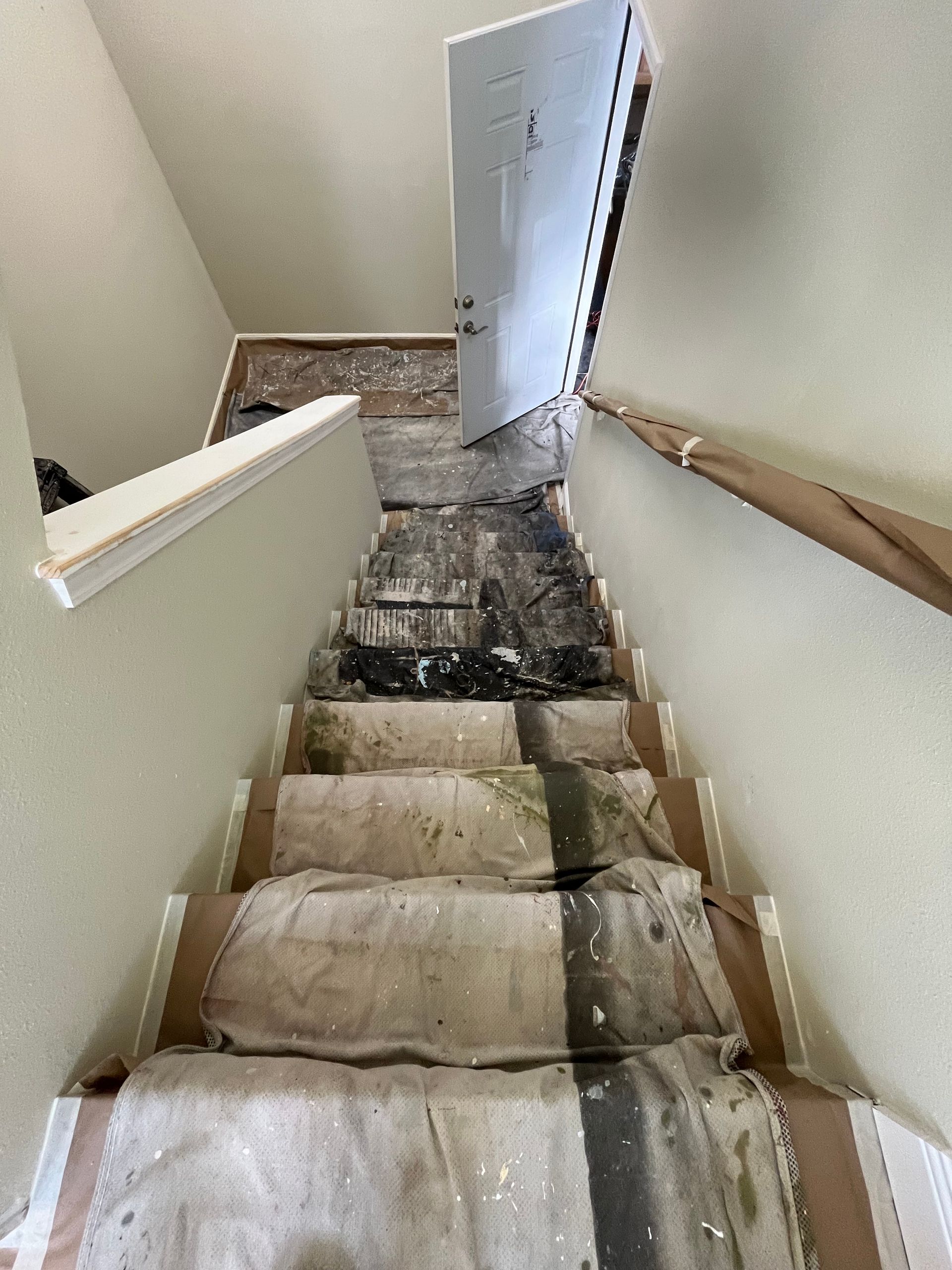 Staircase with damaged treads and exposed wood, door at the top.