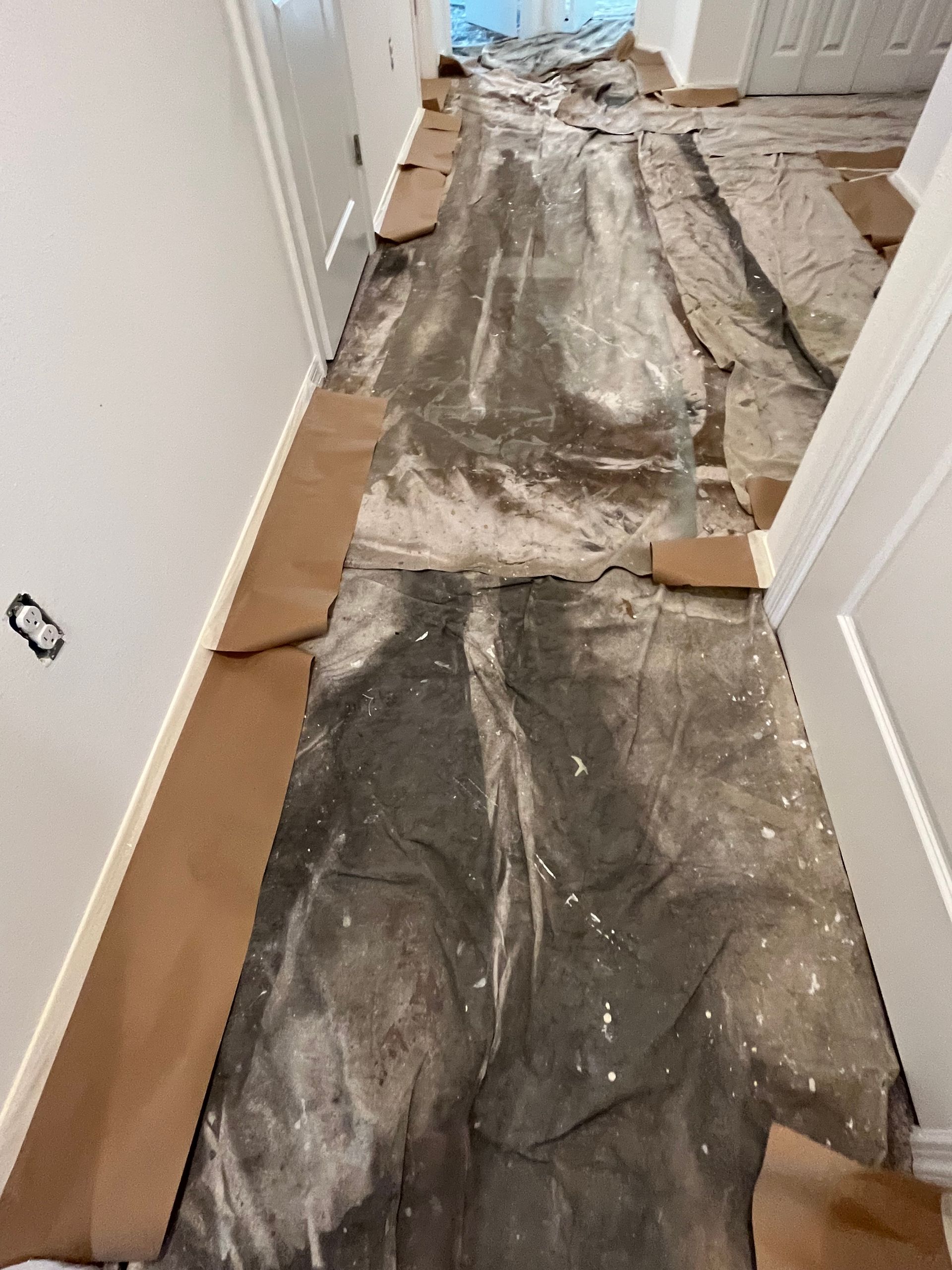 Hallway floor covered with protective material, ready for painting.