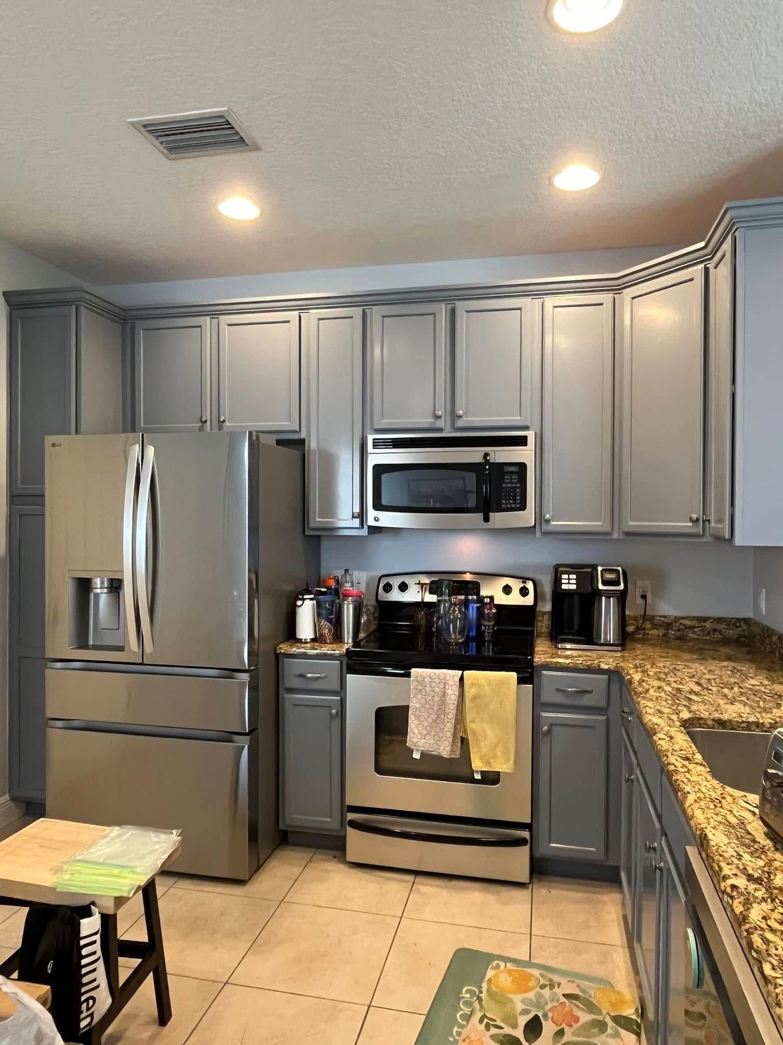 Kitchen with gray cabinets, stainless steel appliances, and granite countertops.