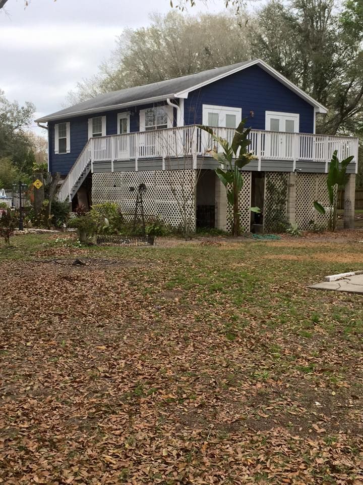 Black and white staircase with spindles. A clock hangs on the beige wall.