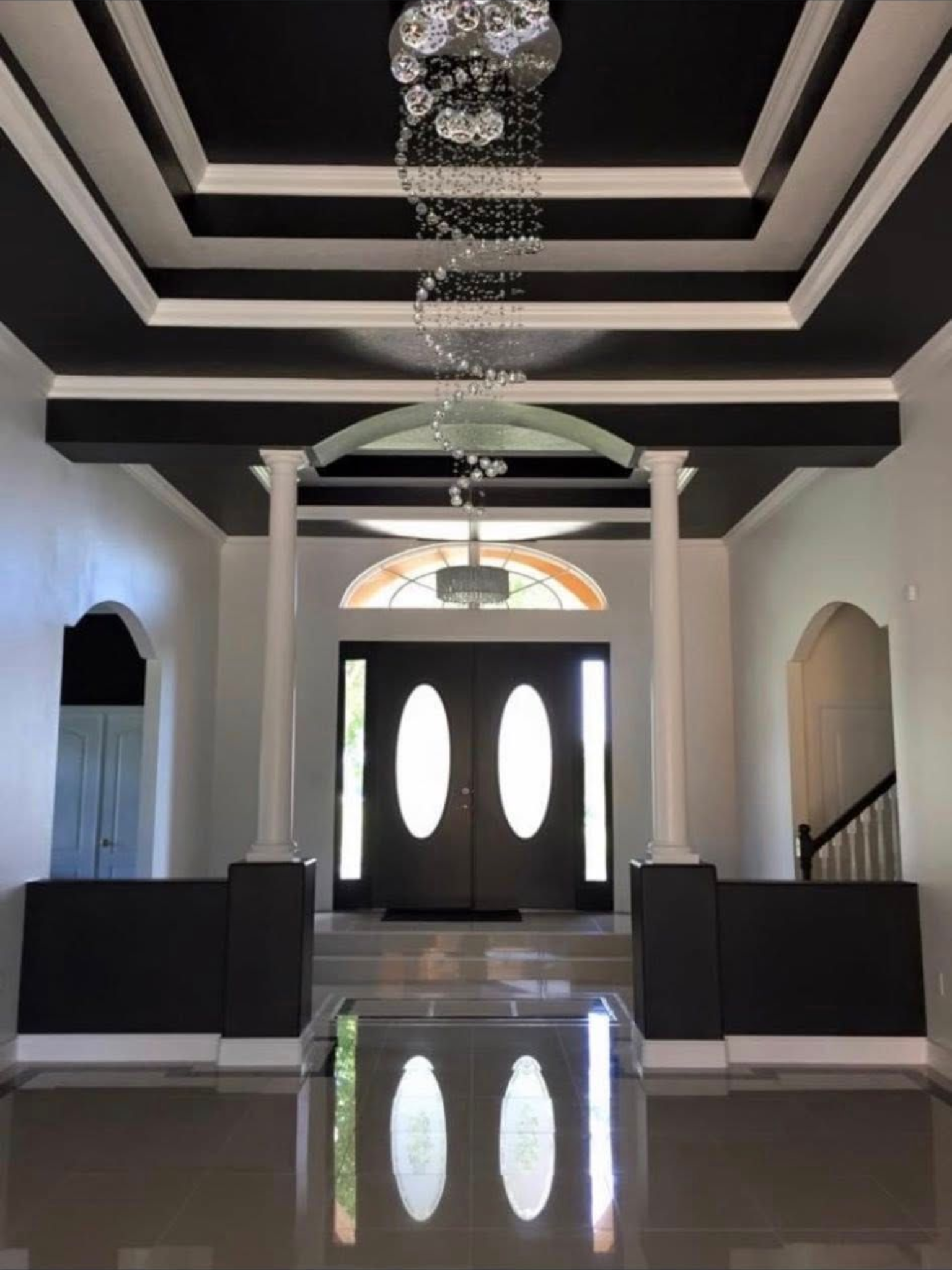 Black and white staircase with spindles. A clock hangs on the beige wall.