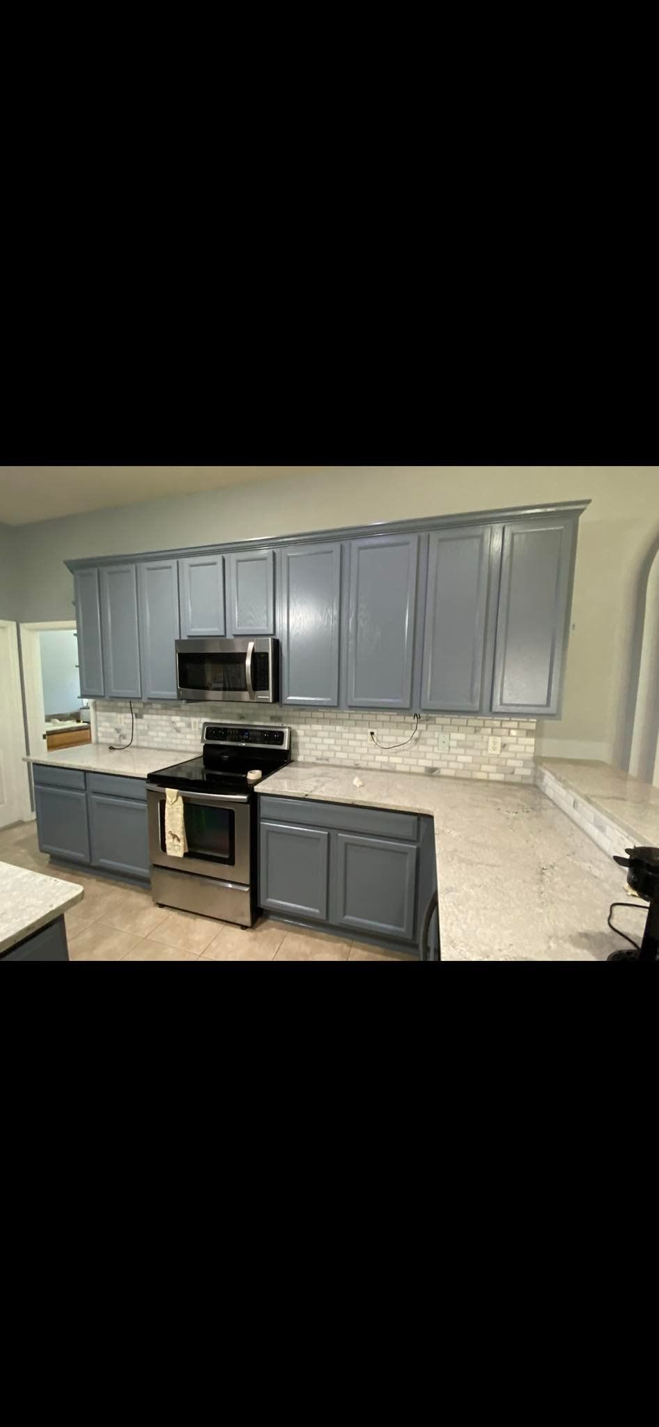 Kitchen with gray cabinets, stainless steel appliances, and white countertops.
