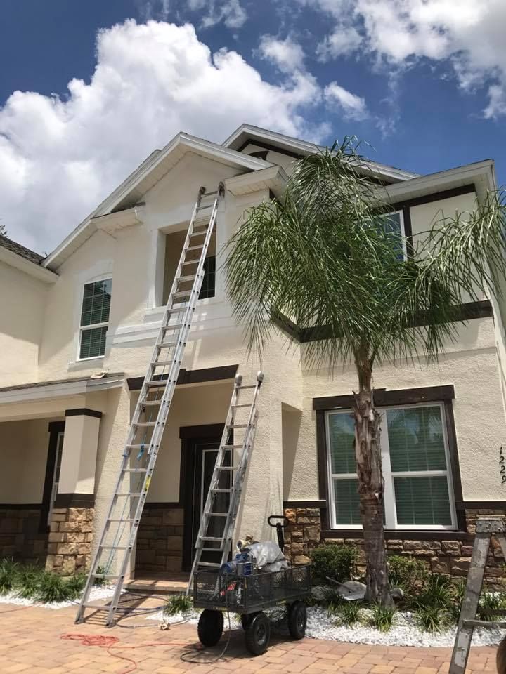 Wooden staircase with white railing, leading down to a front door with a chandelier and clock above.