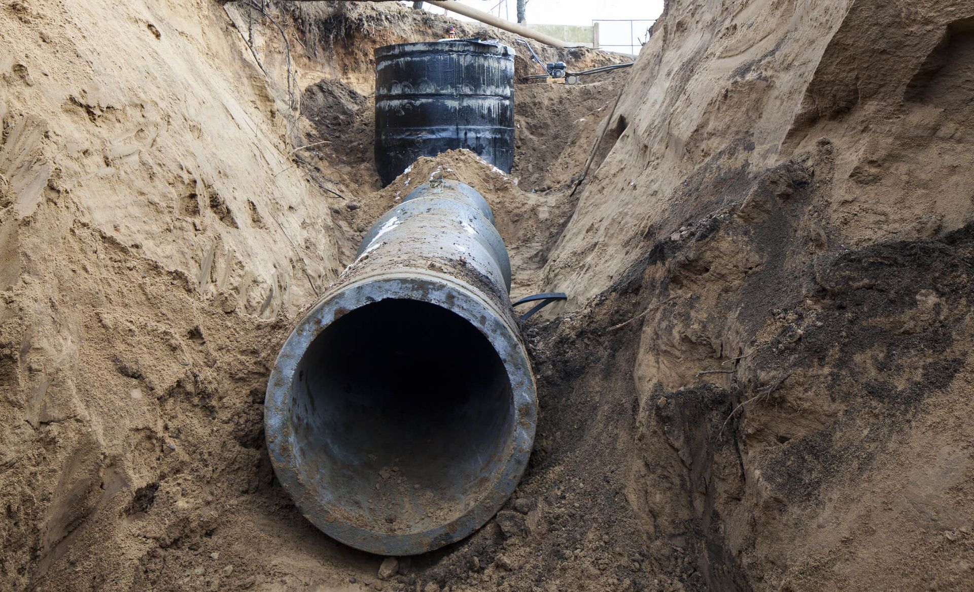 A man wearing a mask and gloves is working on a pipe.