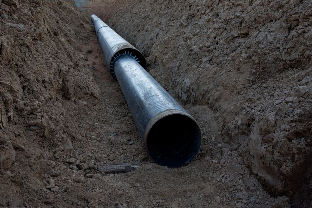 A man wearing a mask is working on pipes.