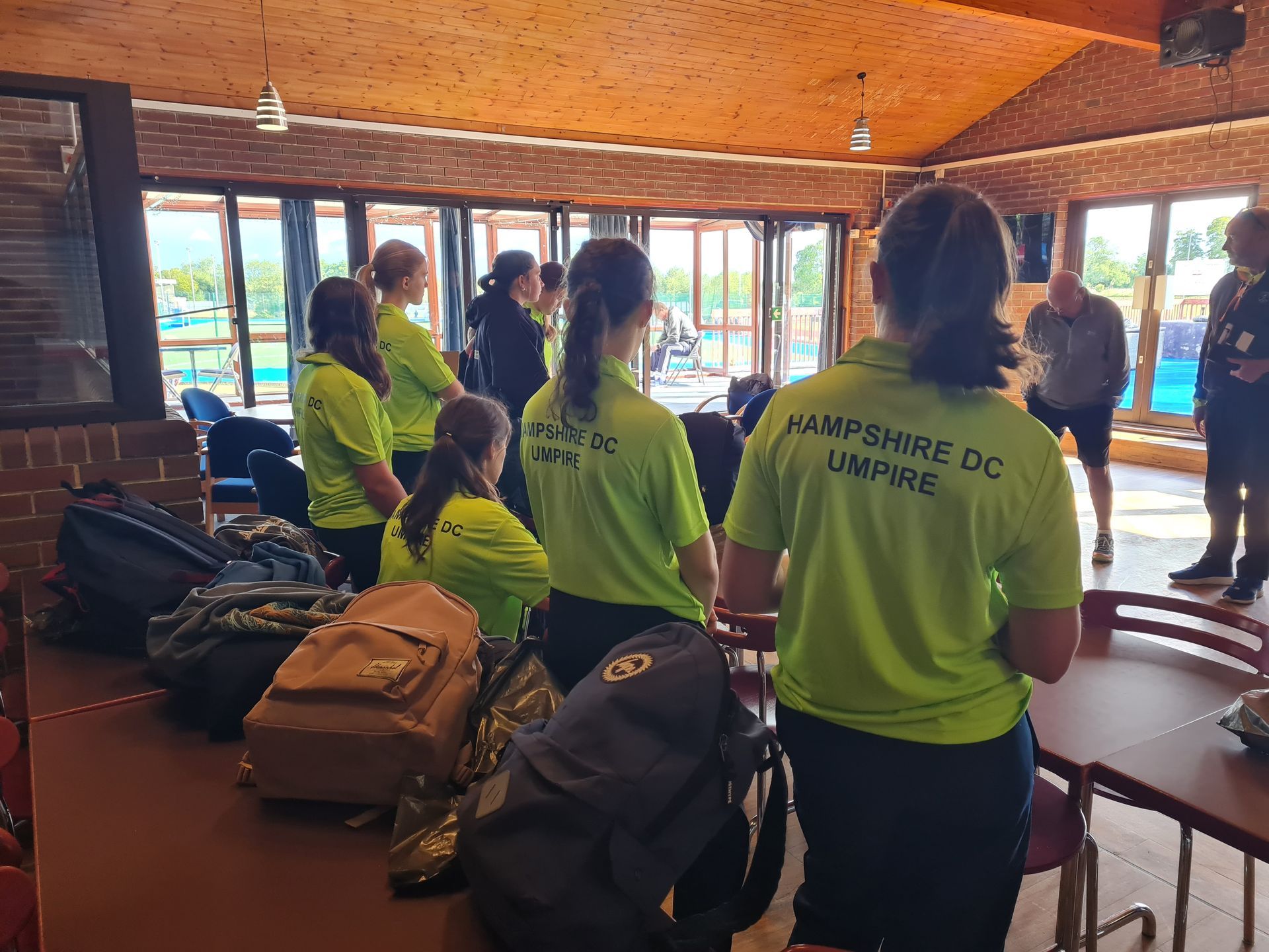 A group of people wearing neon green shirts are standing in a room.