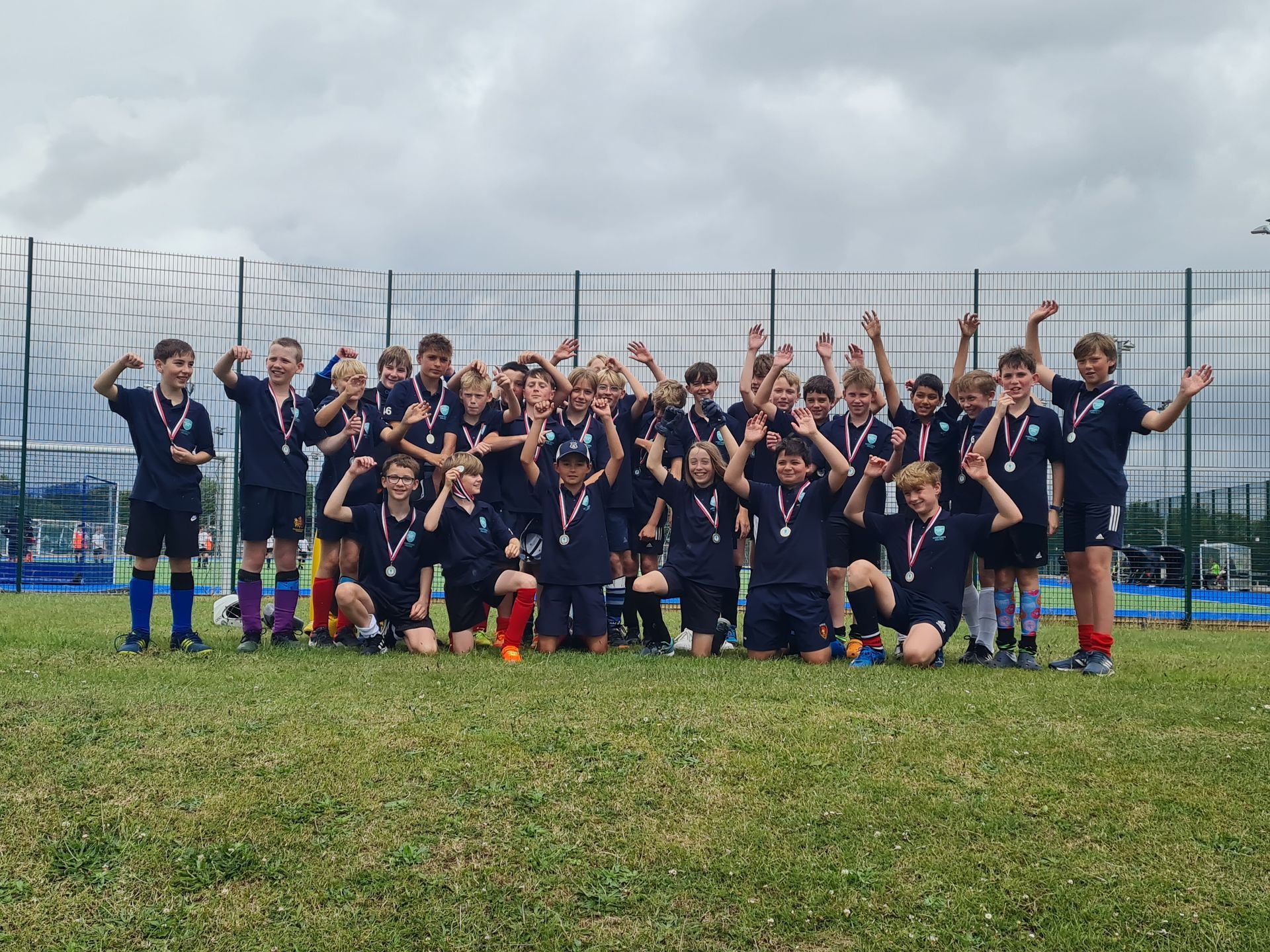 A group of young boys are posing for a picture on a soccer field.