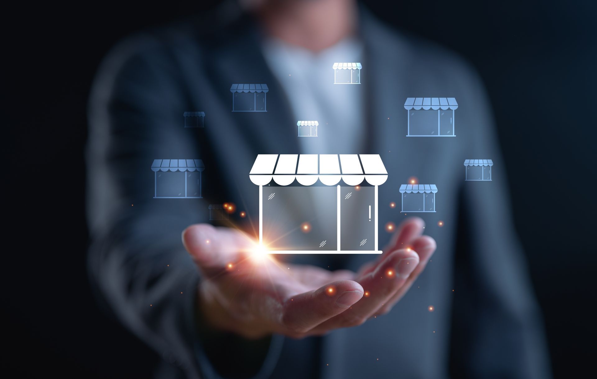 Person holding a glowing shop icon with other shop icons in the background, promoting business or franchising.