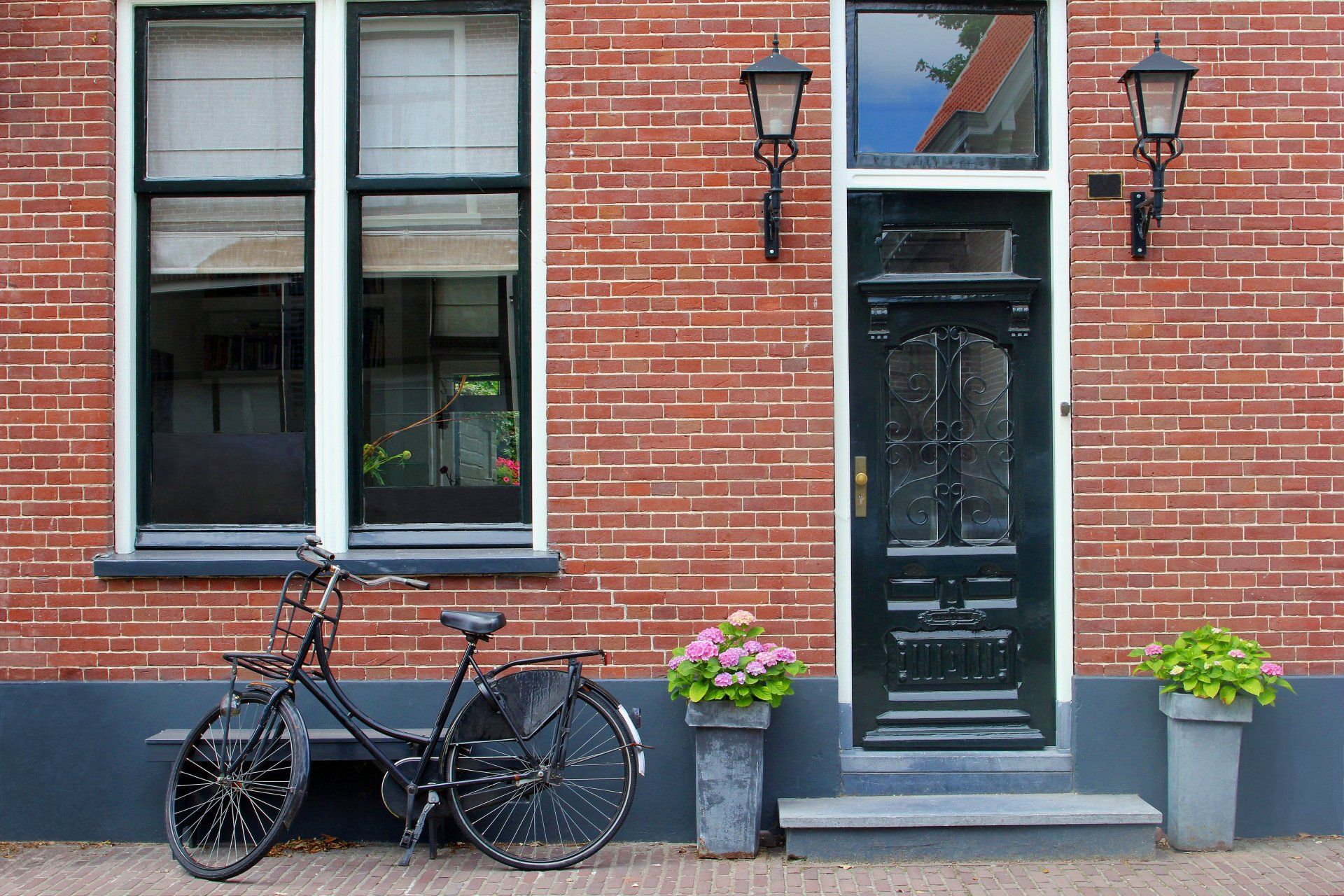 Un vélo est garé devant un bâtiment en brique