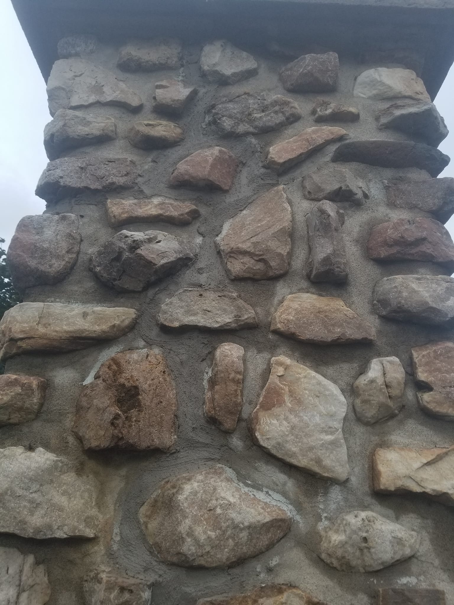 Un mur de pierre surmonté d'une cheminée.
