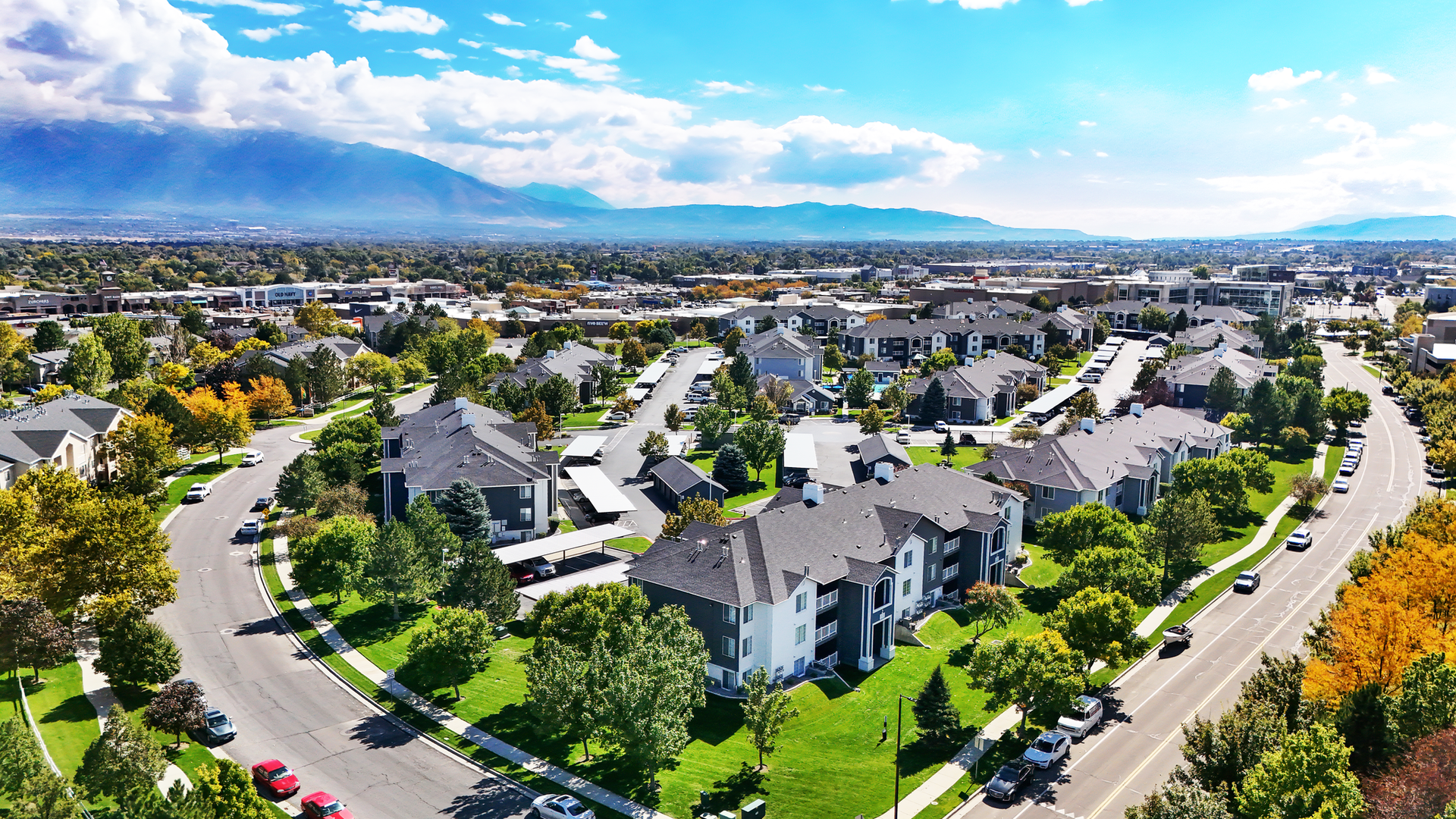 Aerial view of a sprawling apartment community with green lawns and curved roads.