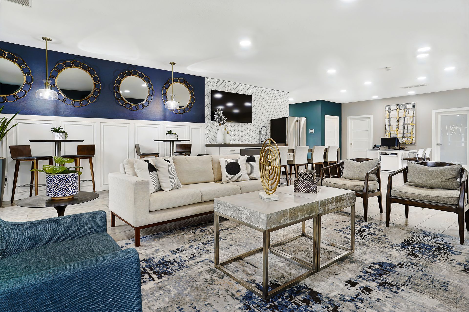 Bright modern resident lounge with sofas, chairs, and a central coffee table in a stylish lobby.