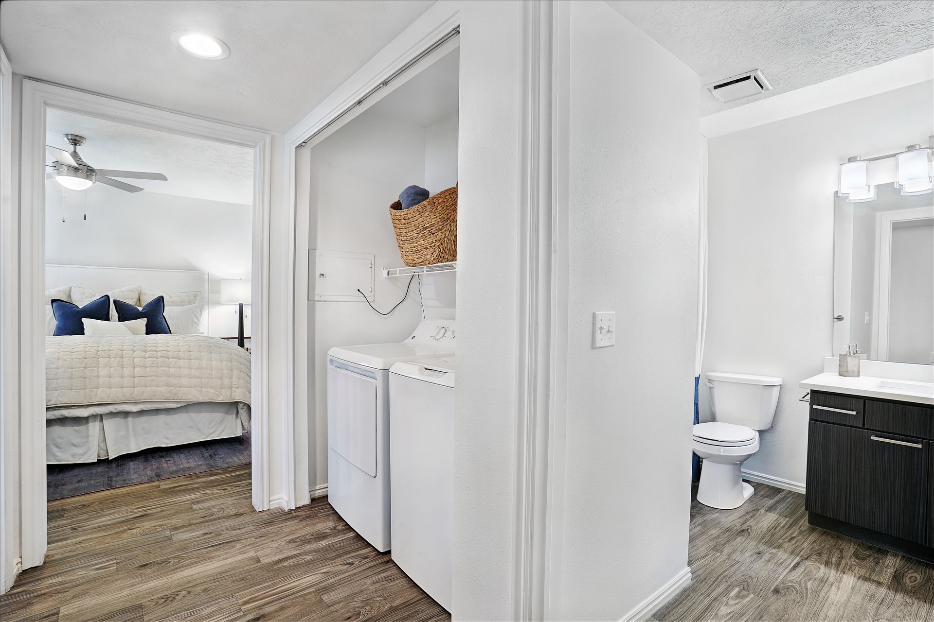 Interior of an apartment with a laundry closet, bedroom doorway, and bathroom vanity at Woodgate.