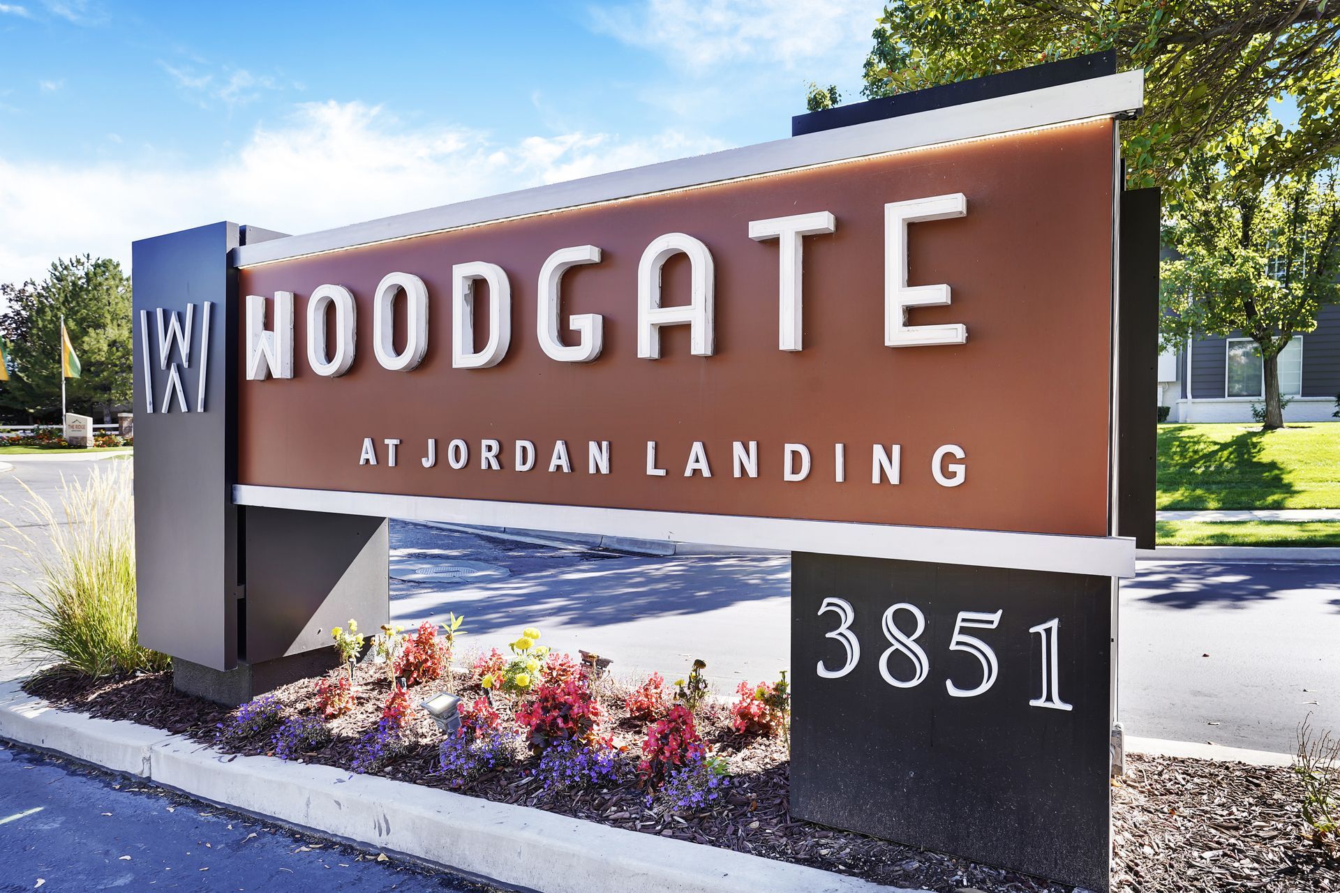 Exterior entrance sign for Woodgate at Jordan Landing with landscaped bed.