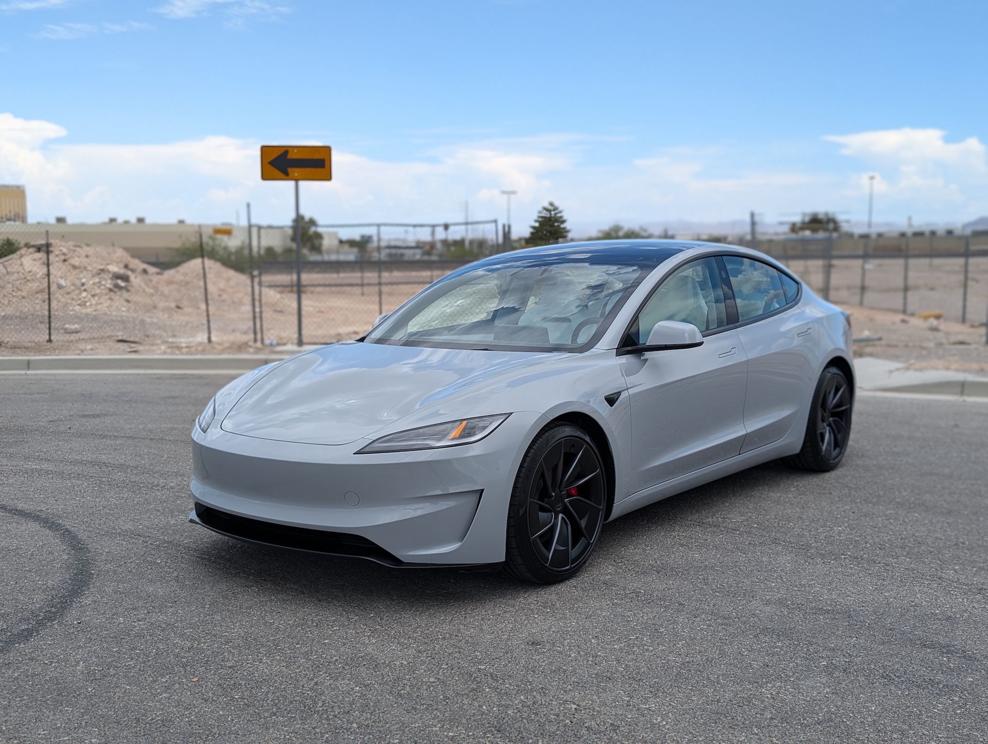 A person wearing black gloves is touching a tire