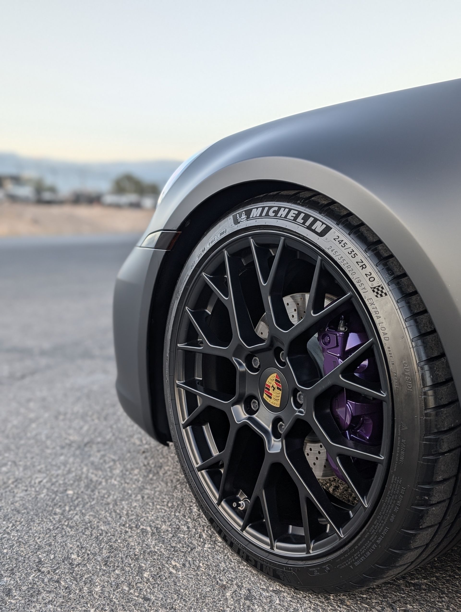 A close up of a car 's tire on a road.