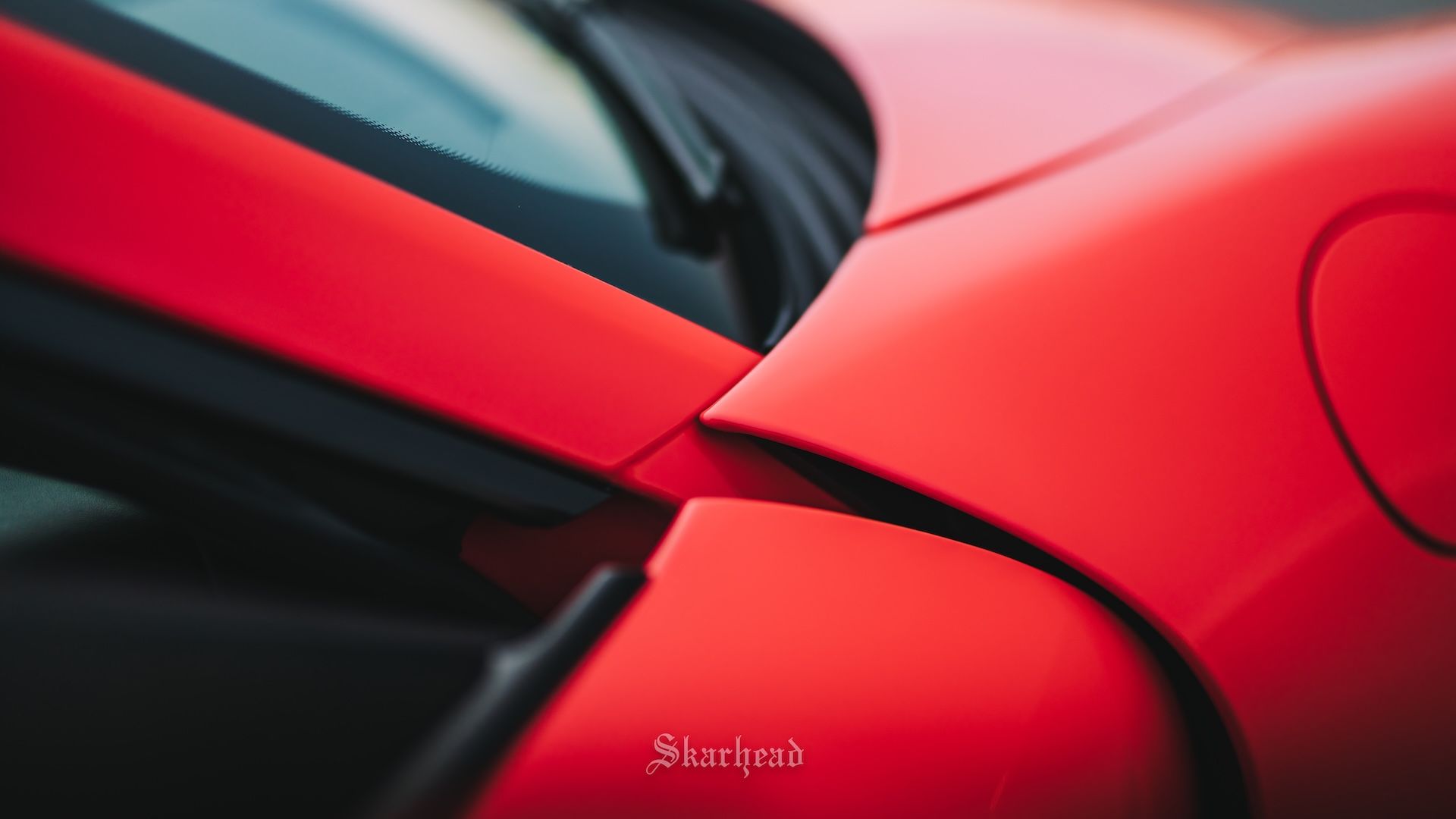 A close up of a red car with a black hood