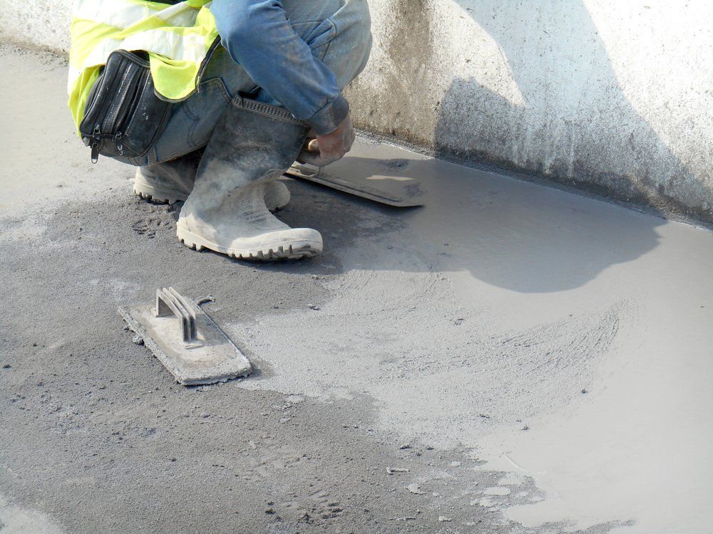 Construction Worker Levelling Wet Concrete — East Coast Cement Rendering in Lismore, NSW