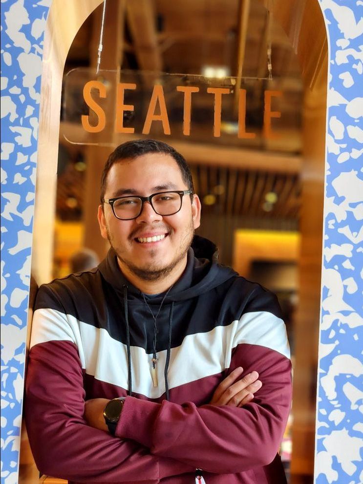 A man is standing in front of a sign that says seattle