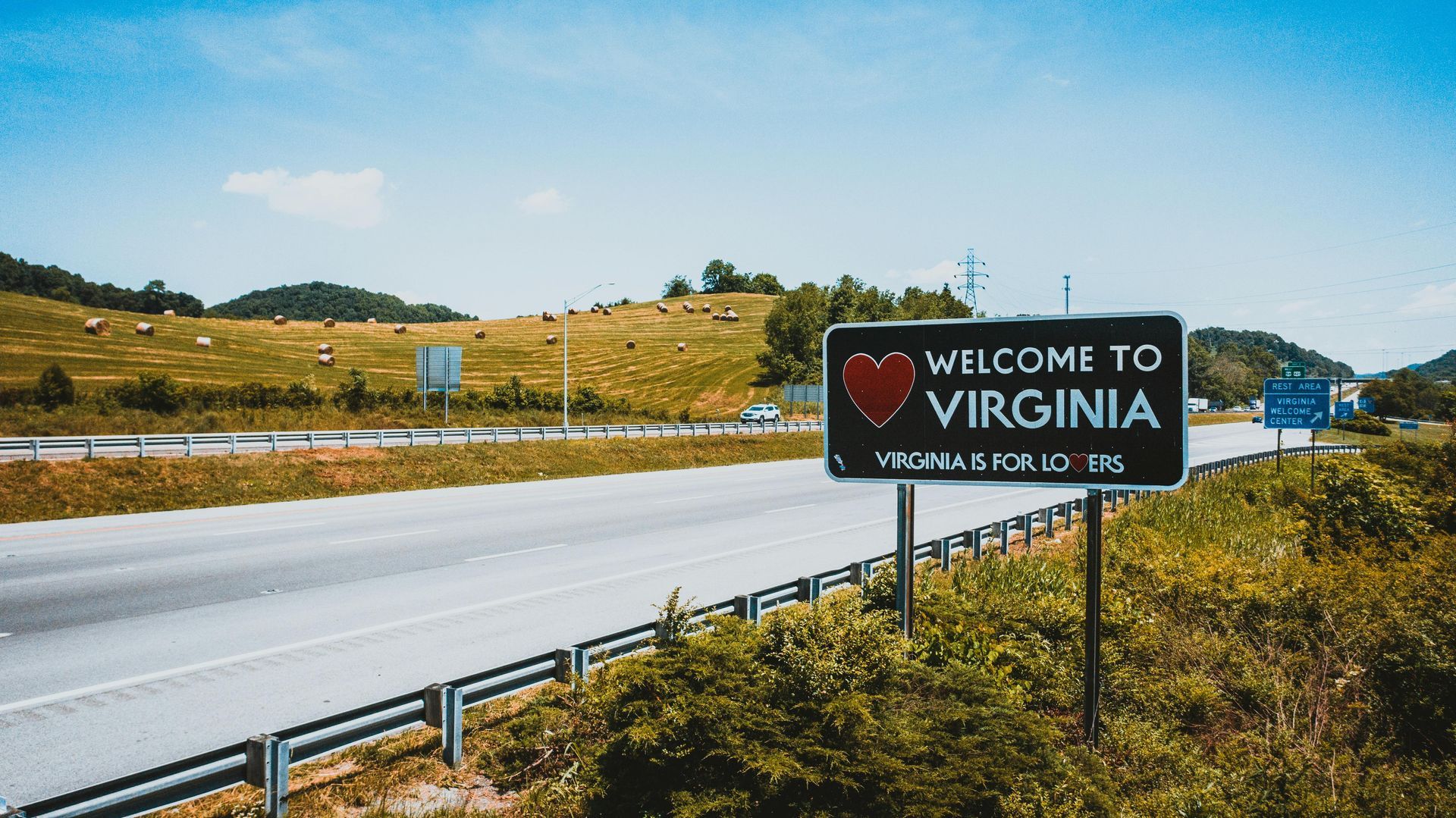 A welcome to virginia sign is on the side of a highway.