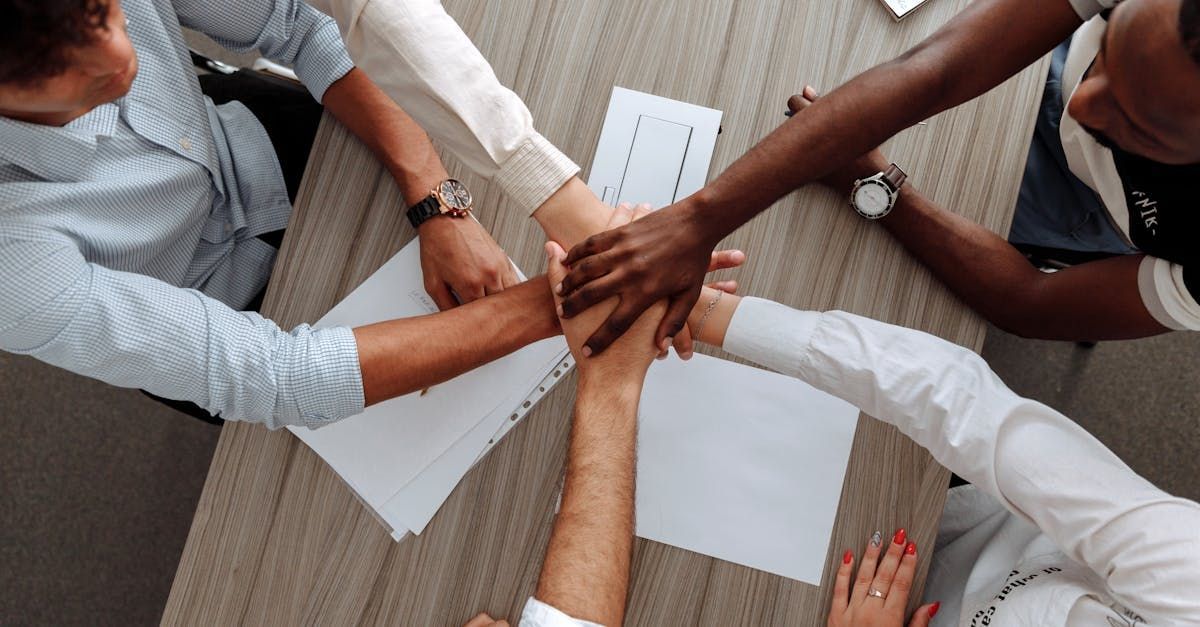 A group of people are putting their hands together in a circle.