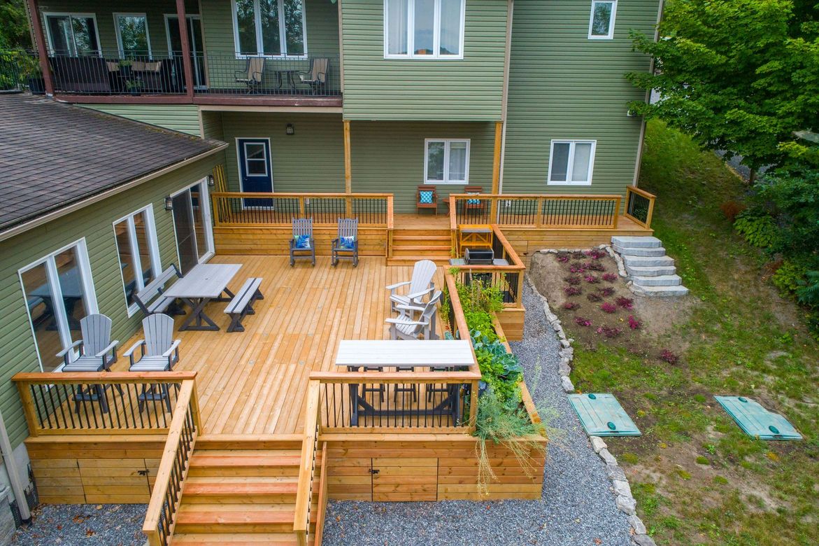 An aerial view of a large wooden deck in front of a house.