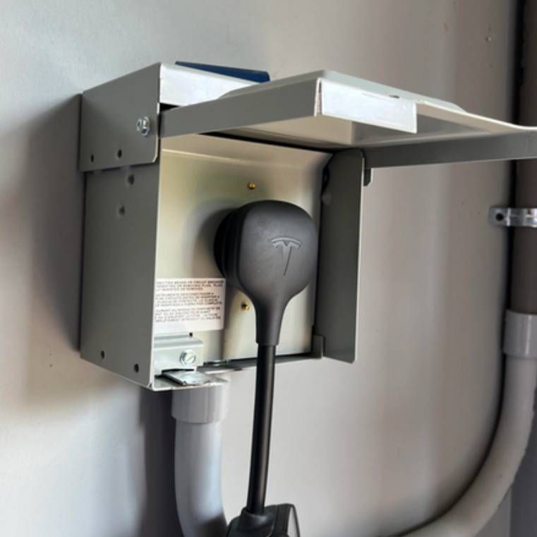 Solar panel array in grassy field with trees in the background.