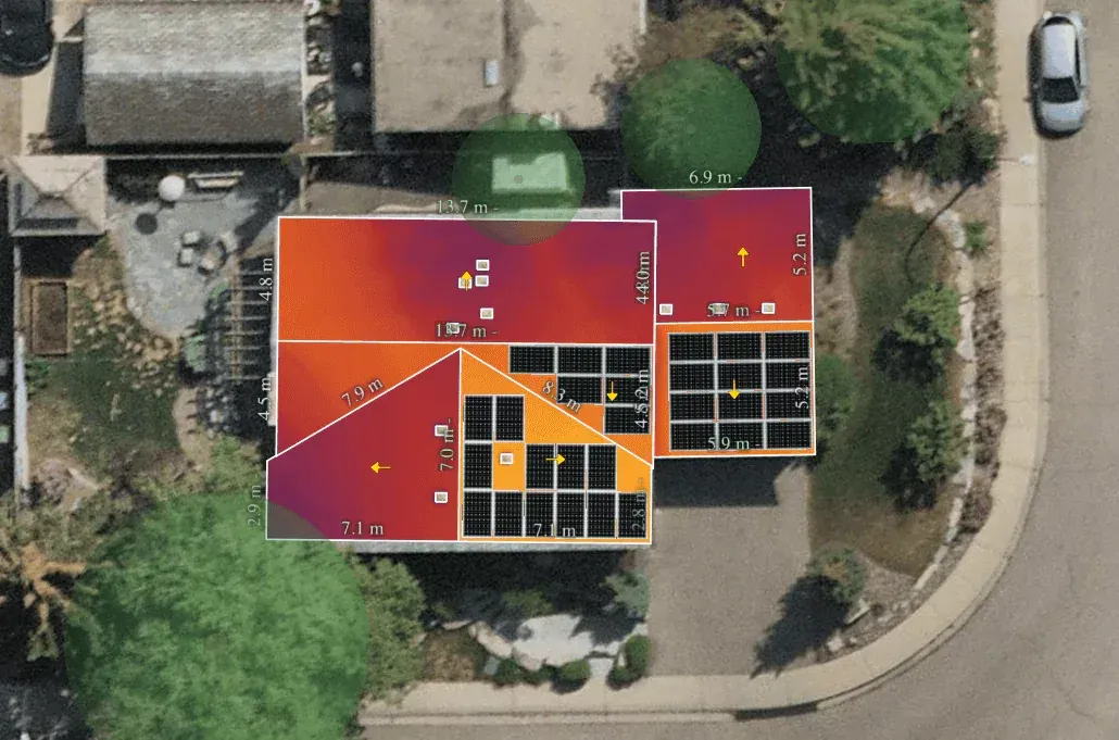 Aerial view of a house roof with solar panel potential map; red, yellow, and purple hues indicate sun exposure.
