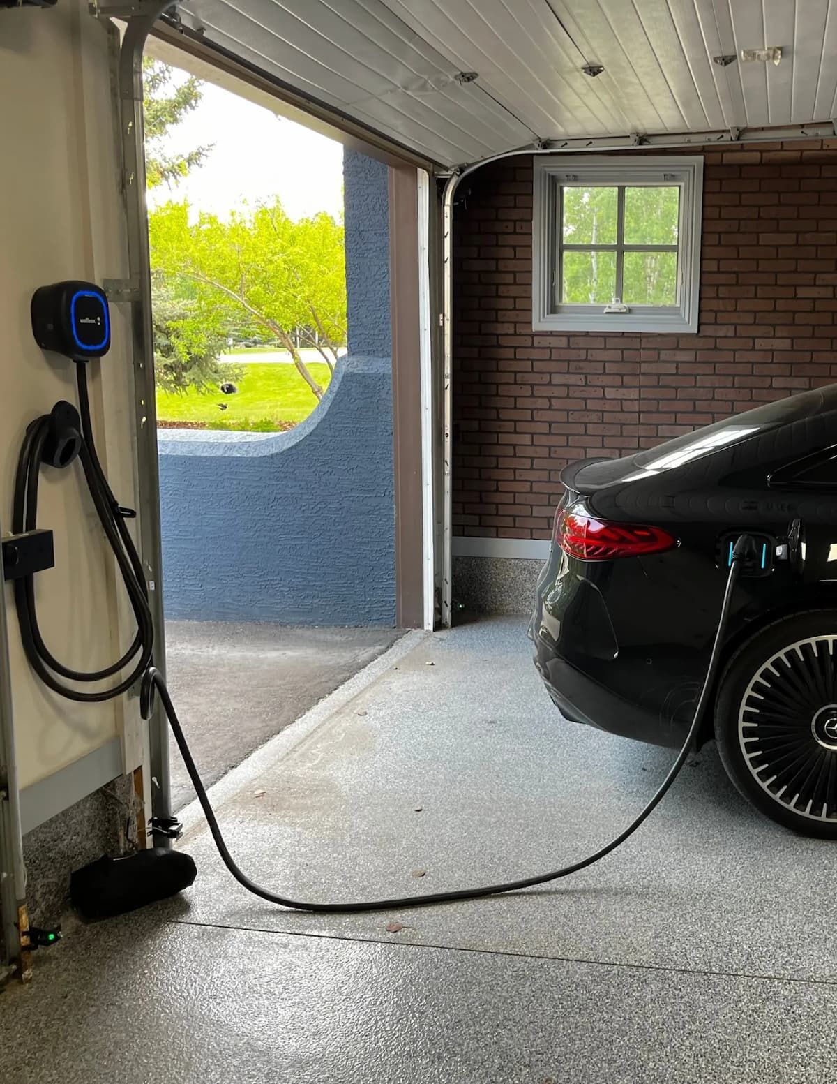 House exterior with police vehicles parked in the driveway; snow-covered ground and trees.