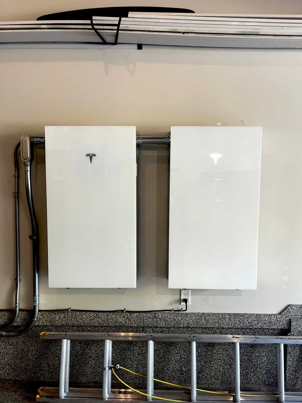 A house with solar panels installed nestled in a hillside of golden autumn trees, under a blue sky.