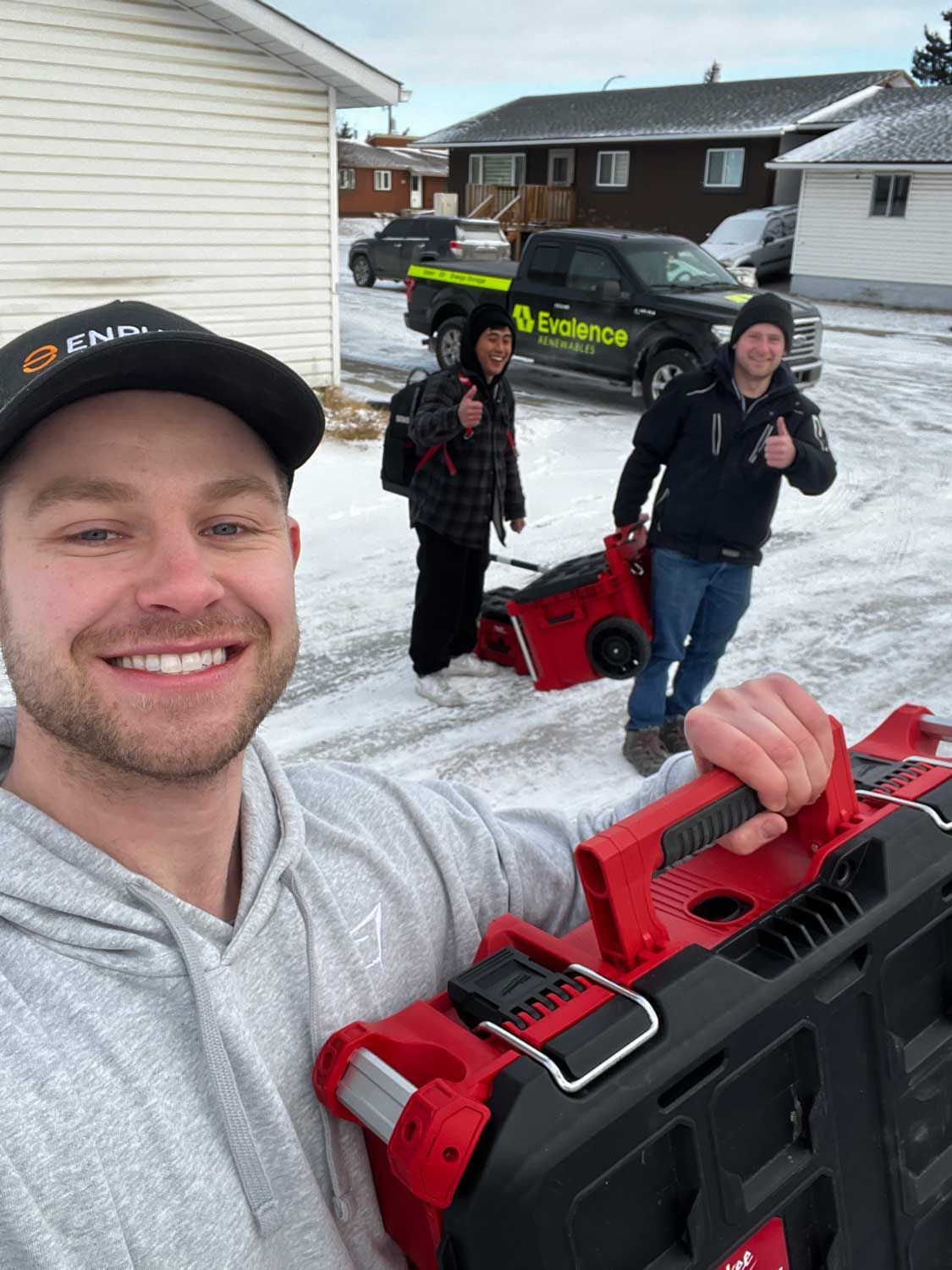 Delivery worker writing on a clipboard by a van loaded with packages.