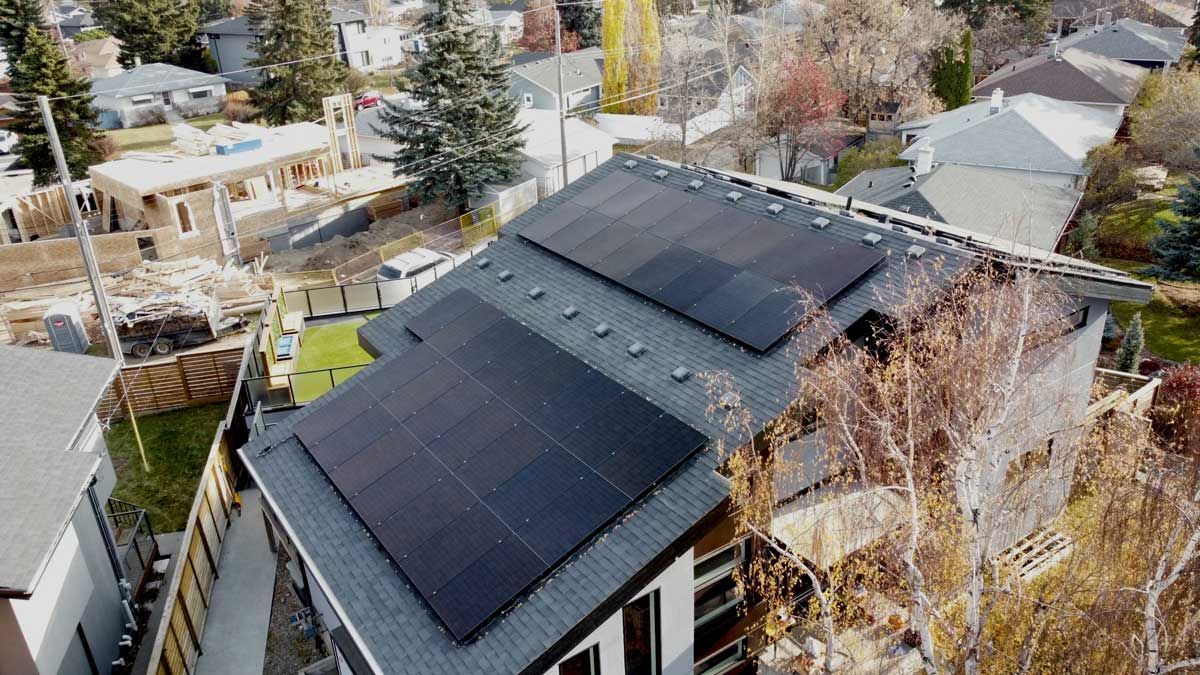 Solar panels installed on a residential rooftop. Overlook of a suburban neighborhood.