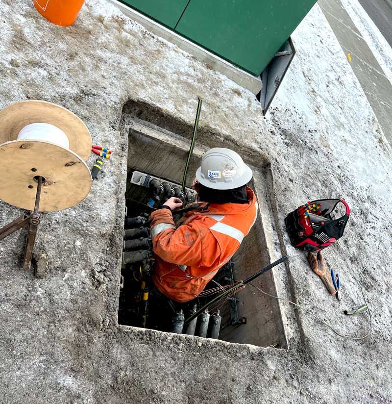 Two workers in helmets install solar panels on a roof.