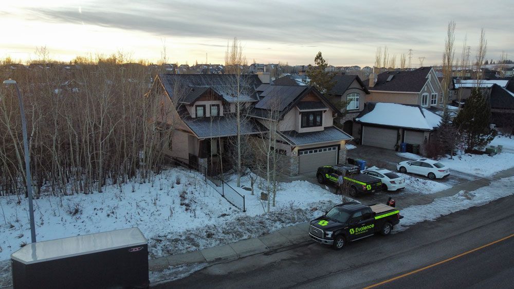 Houses with emergency vehicles parked in front, snow on the ground.