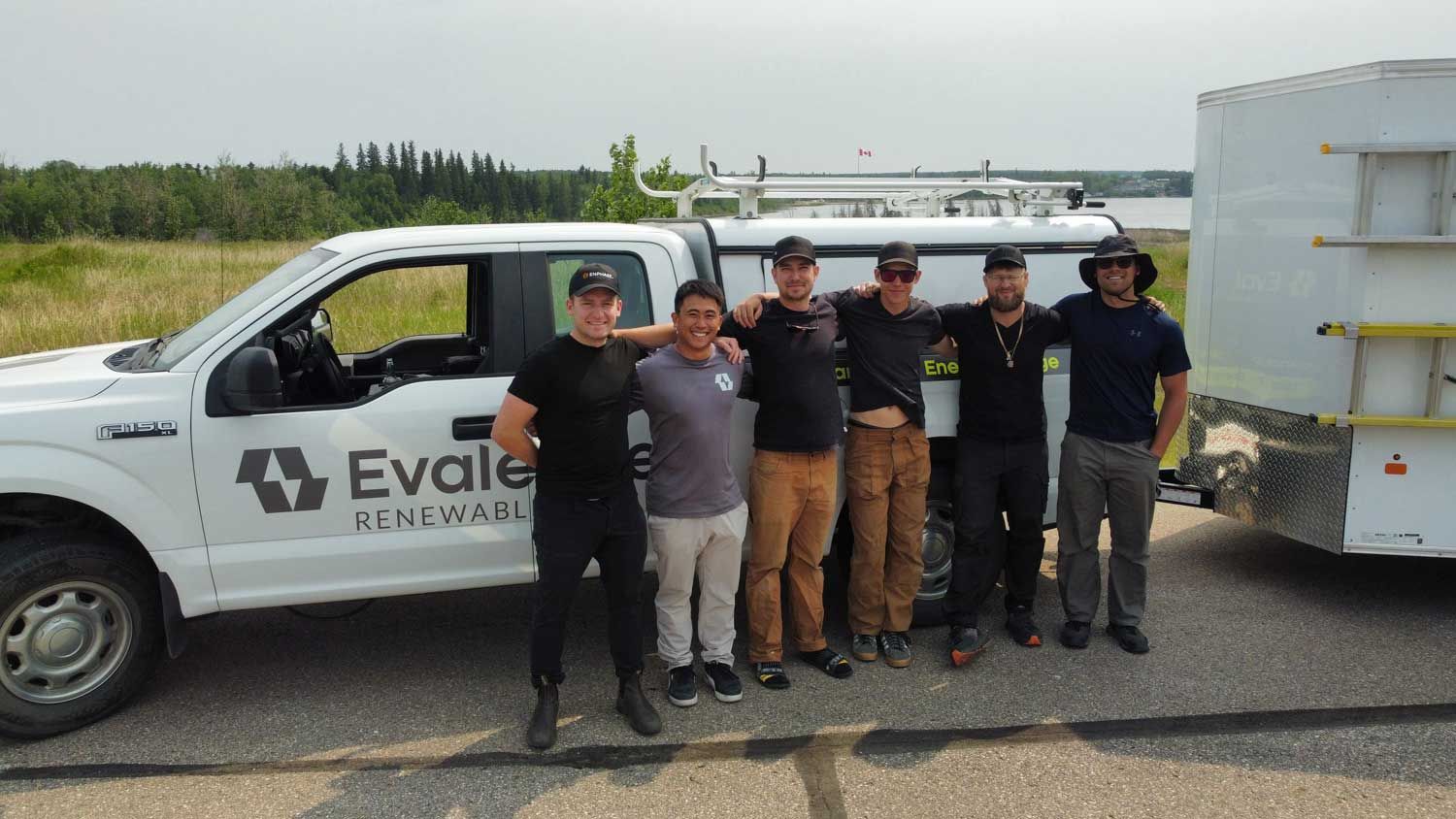 Group of people at a long table enjoying food and drinks, laughing and interacting with each other in a warmly lit room.