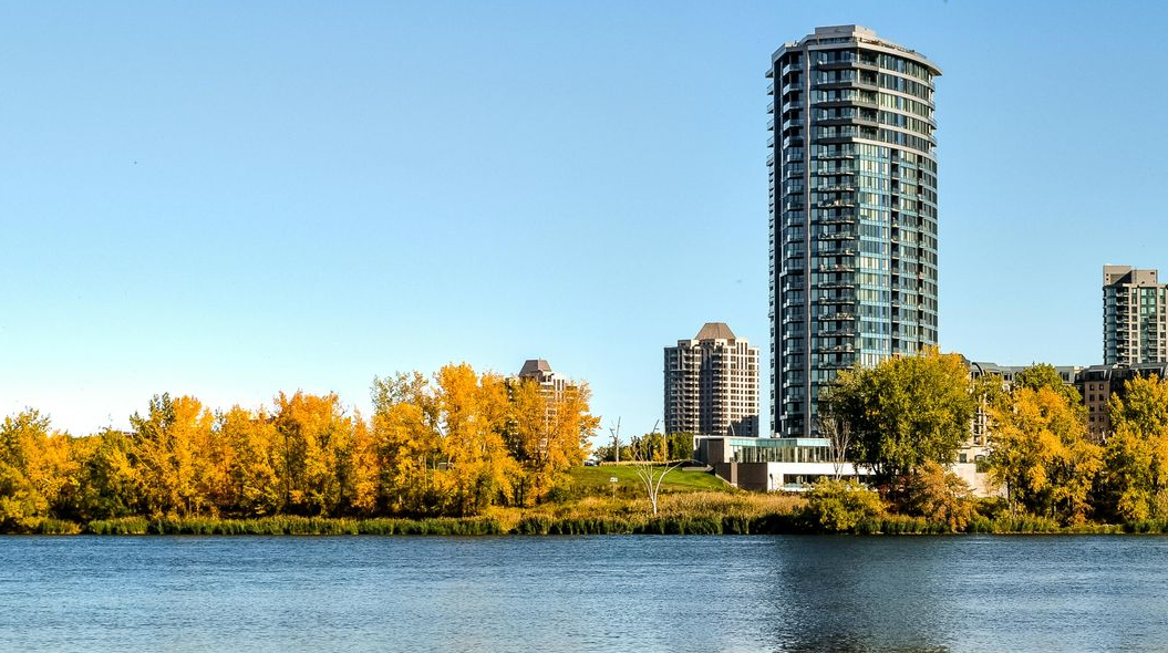 Solar panels on commercial roof with a field and mountains in the background.