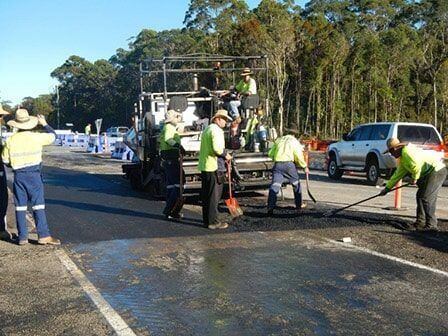 A Group Of Construction Workers Are Working On A Road — Roll Formed Driveways in Sunshine Coast, QLD