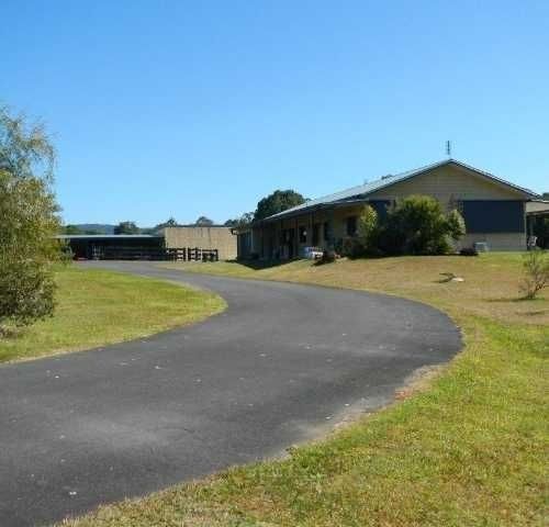 A Road Leading To A Building With A Grass On The Side — Roll Formed Driveways in Yandina, QLD