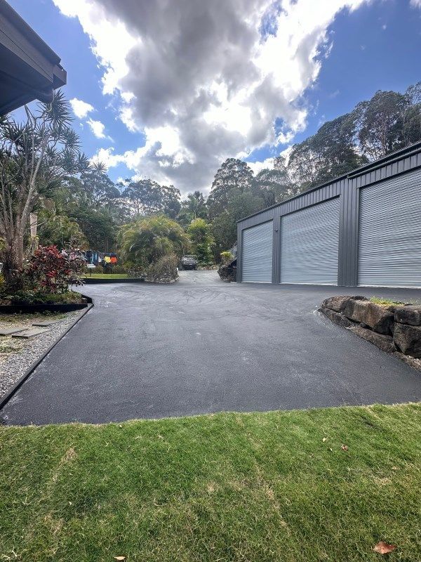 A Driveway Leading To A Garage With A Blue Sky In The Background — Roll Formed Driveways in Kingaroy, QLD
